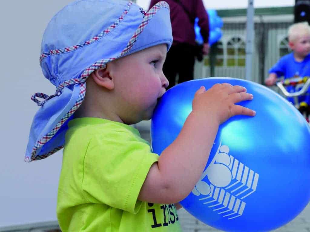 Kleinkind mit Sonnenhut und Luftballon beim Friedbergfest im Wohnpark Friedberg in Suhl